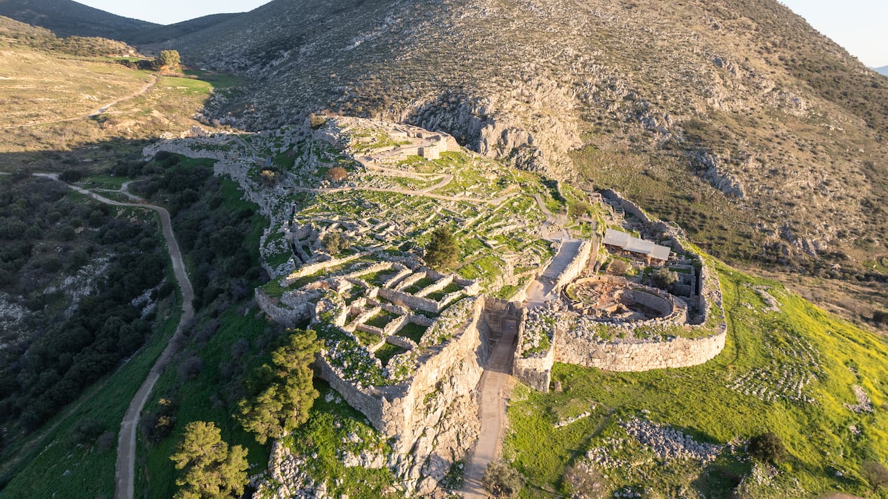 The ruins of a once great palace are seen on a barren hill.