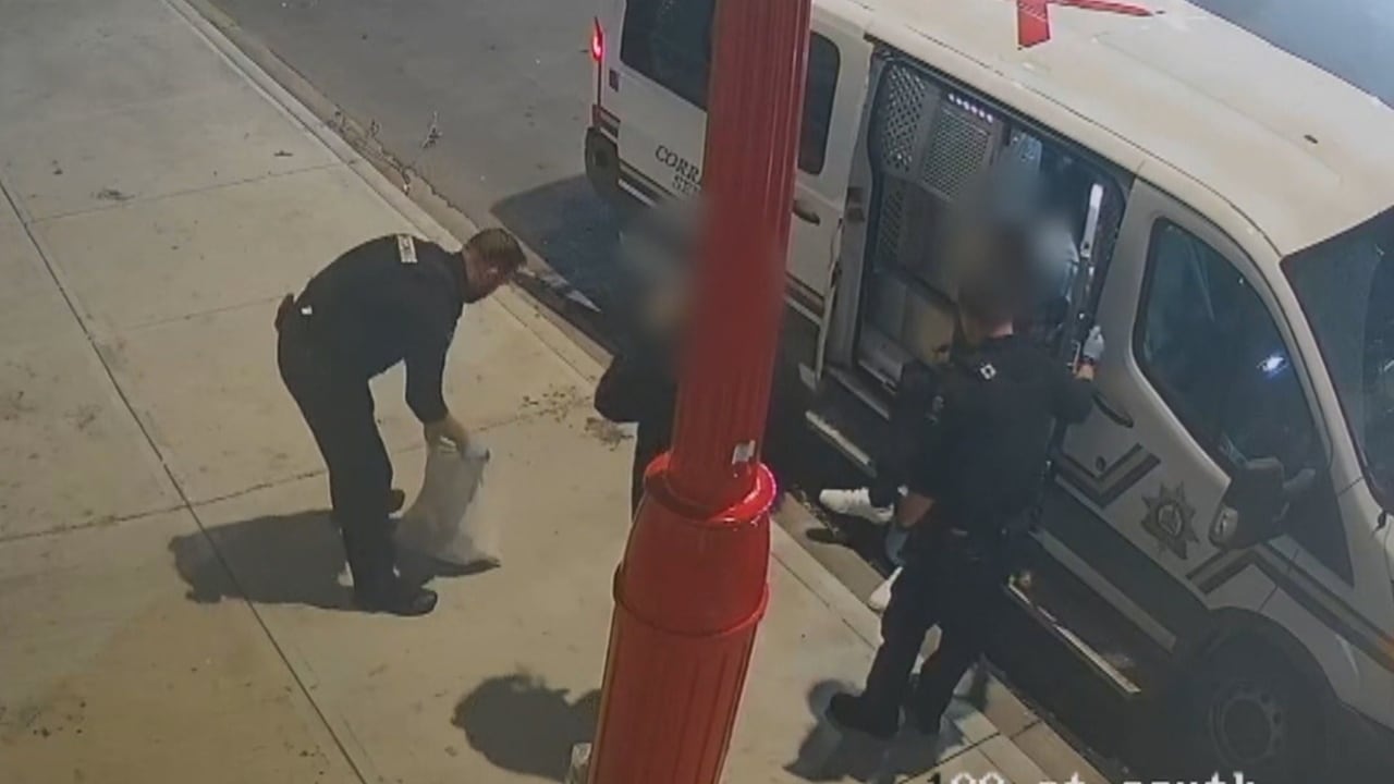 People stand outside a van on a sidewalk.