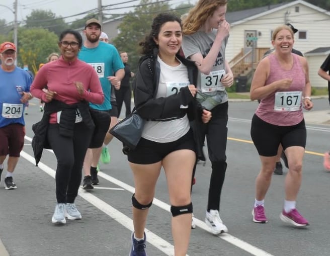 Woman running on road with group of people