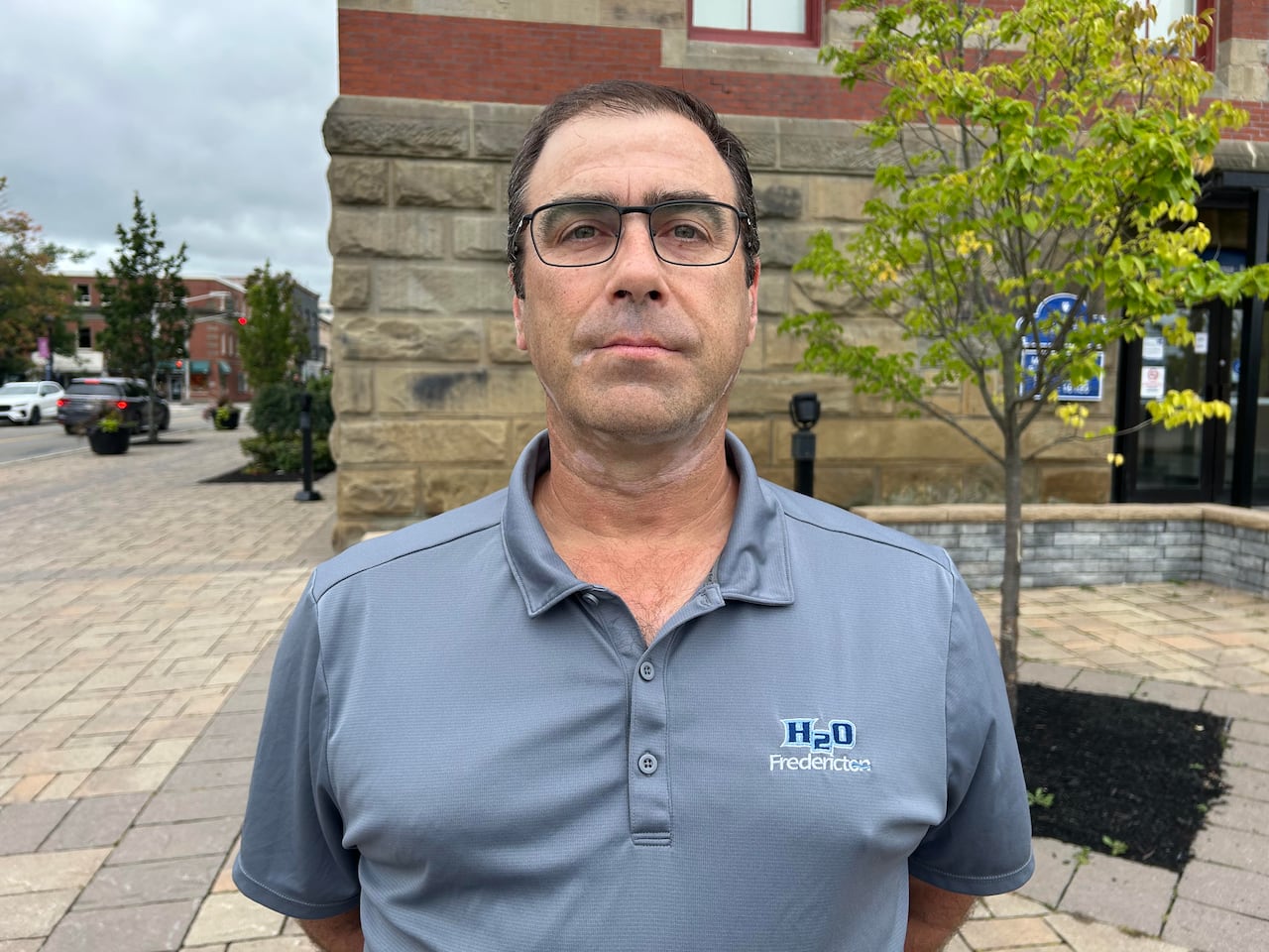 A man with a blue shirt and glasses