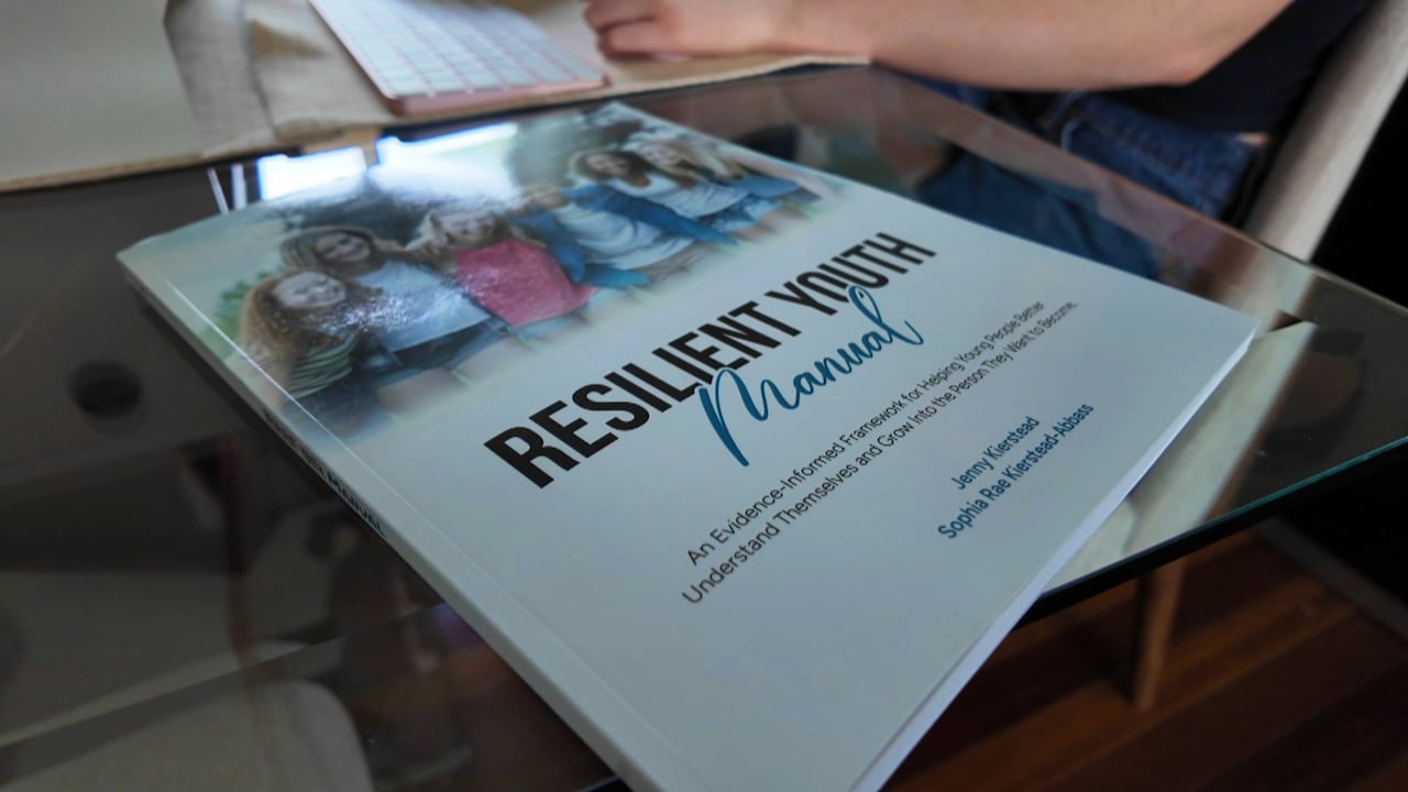 A book lays on top of glass table.