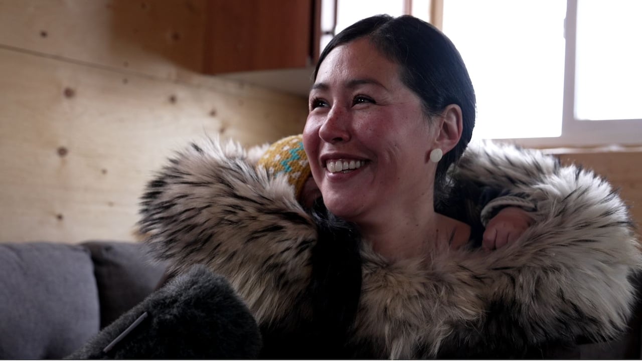 Inuk woman smiling in a cabin