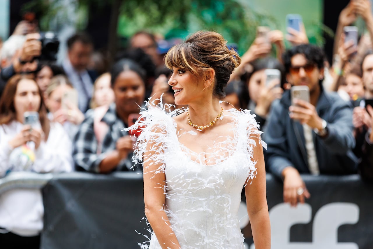 Woman in white dress looks over shoulder.