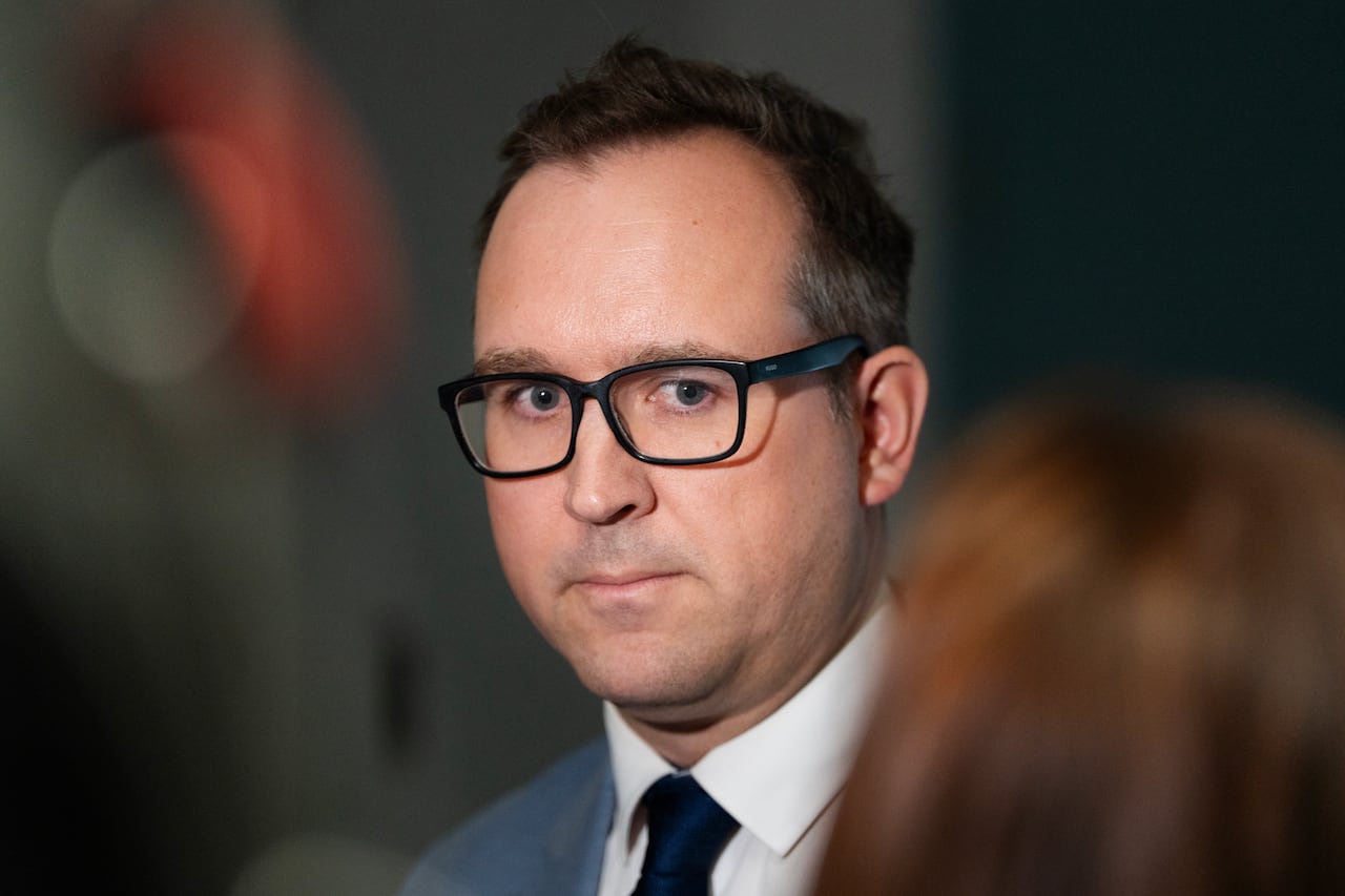 A man in a suit jacket, tie and glasses.