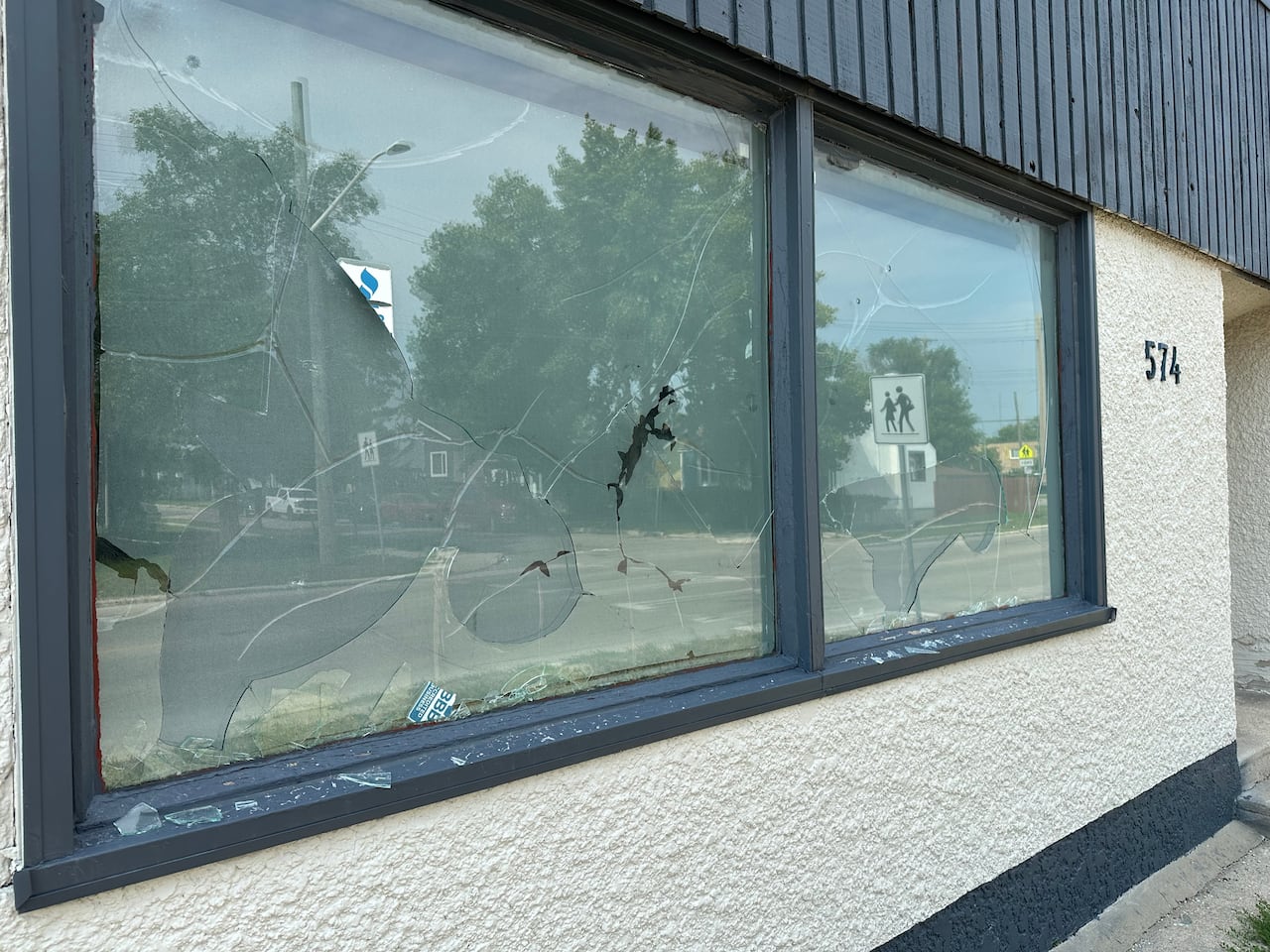 Broken glass windows on the side of a building.