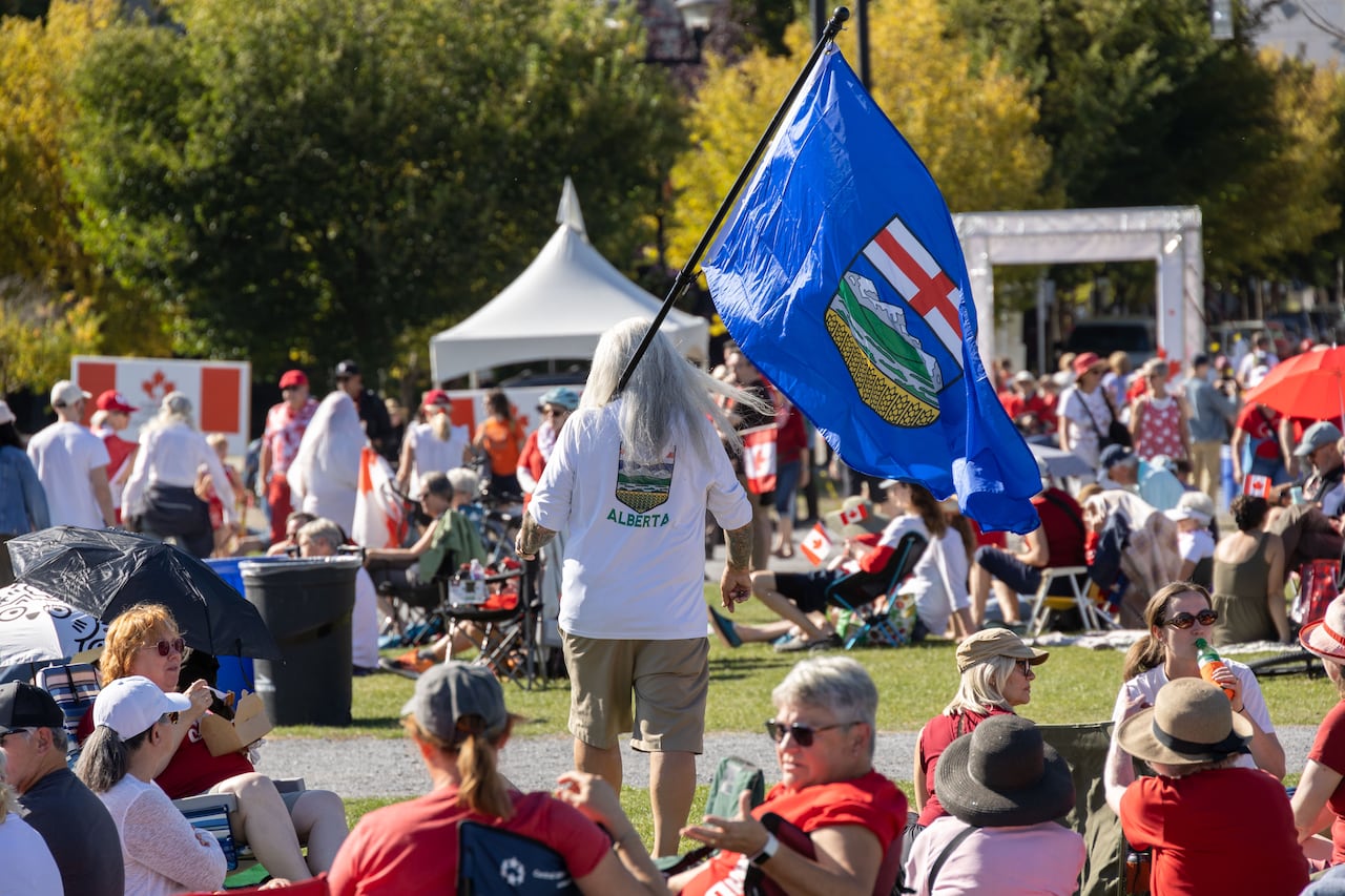 A man holding a blue flag in a crowd.