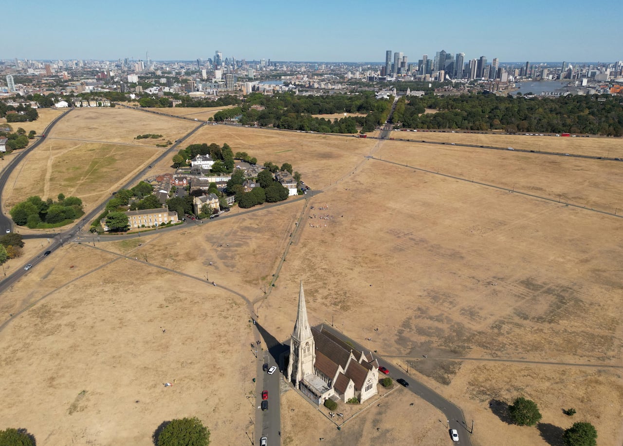 Parched fields are seen from above near a city and with a church in the middle.