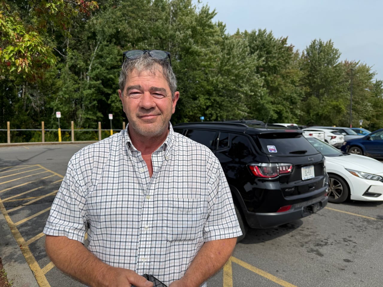 A man stands in a parking lot