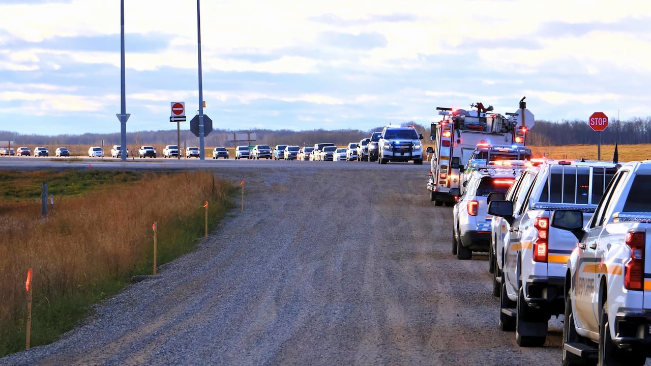 A line of emergency vehicles on a road.