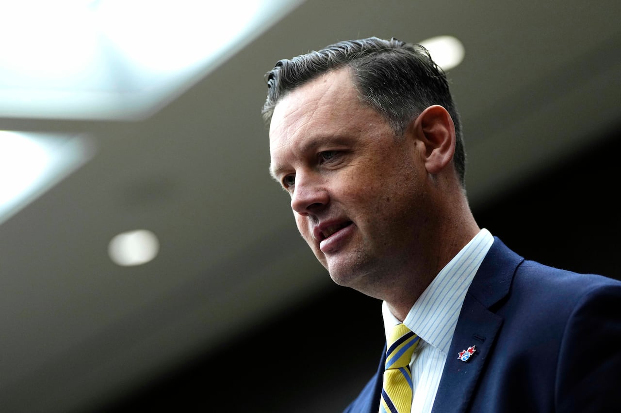 A man in a suit seen from the shoulders up.