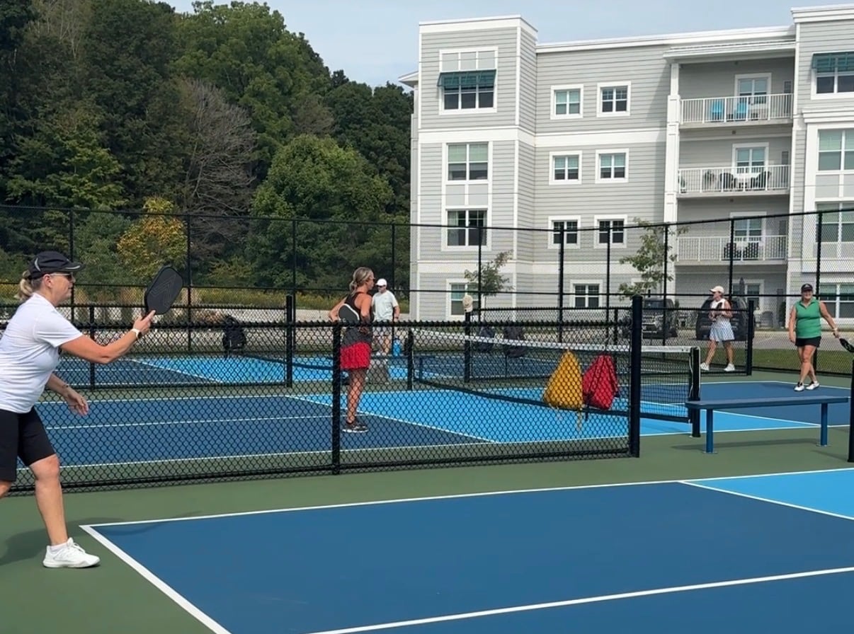 People playing pickleball in front of a condo