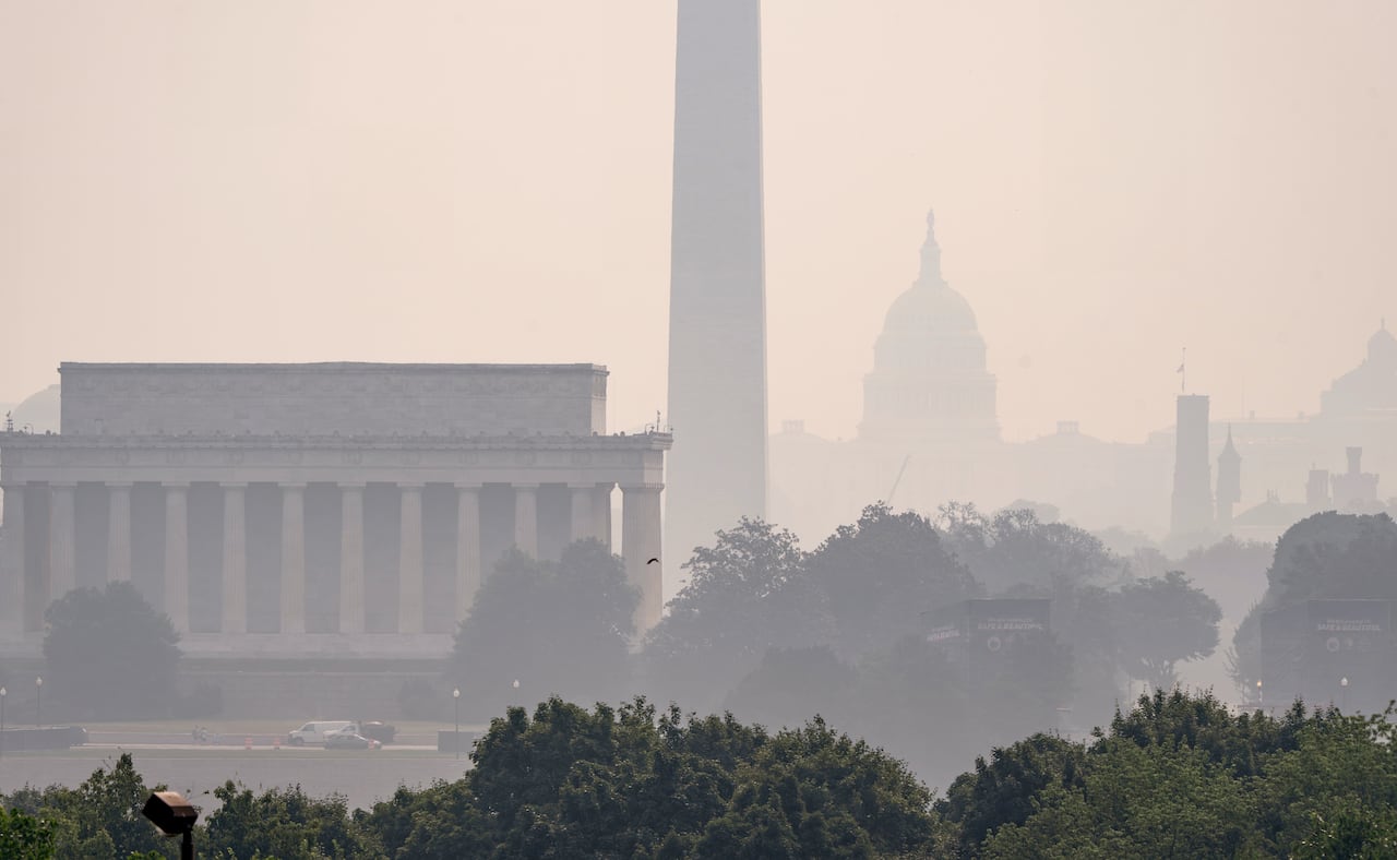 The Lincoln Memorial, the Washington Monument, and the U.S. Capitol, are barely visible from an overlook in Arlington, Va., as heavy smoke from wildfires shrouds the landscape in Washington.