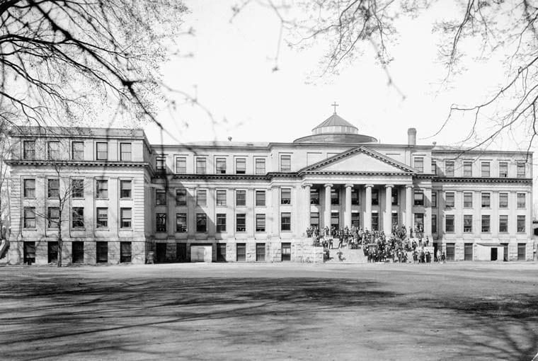 A black-and-white wide shot of a large four-storey building.