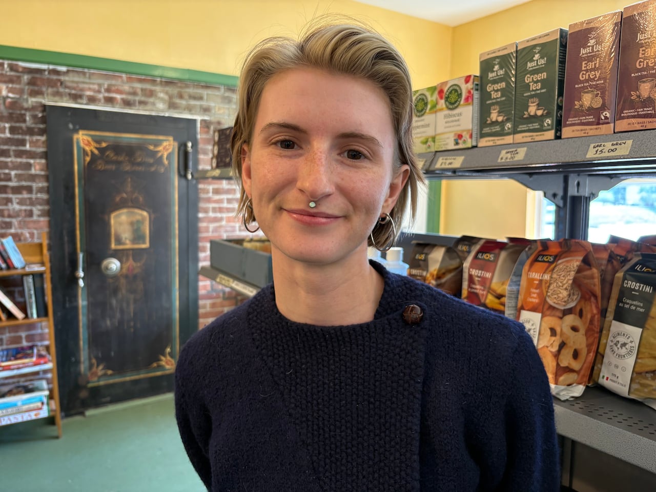 A person stands in front of shelves of food.