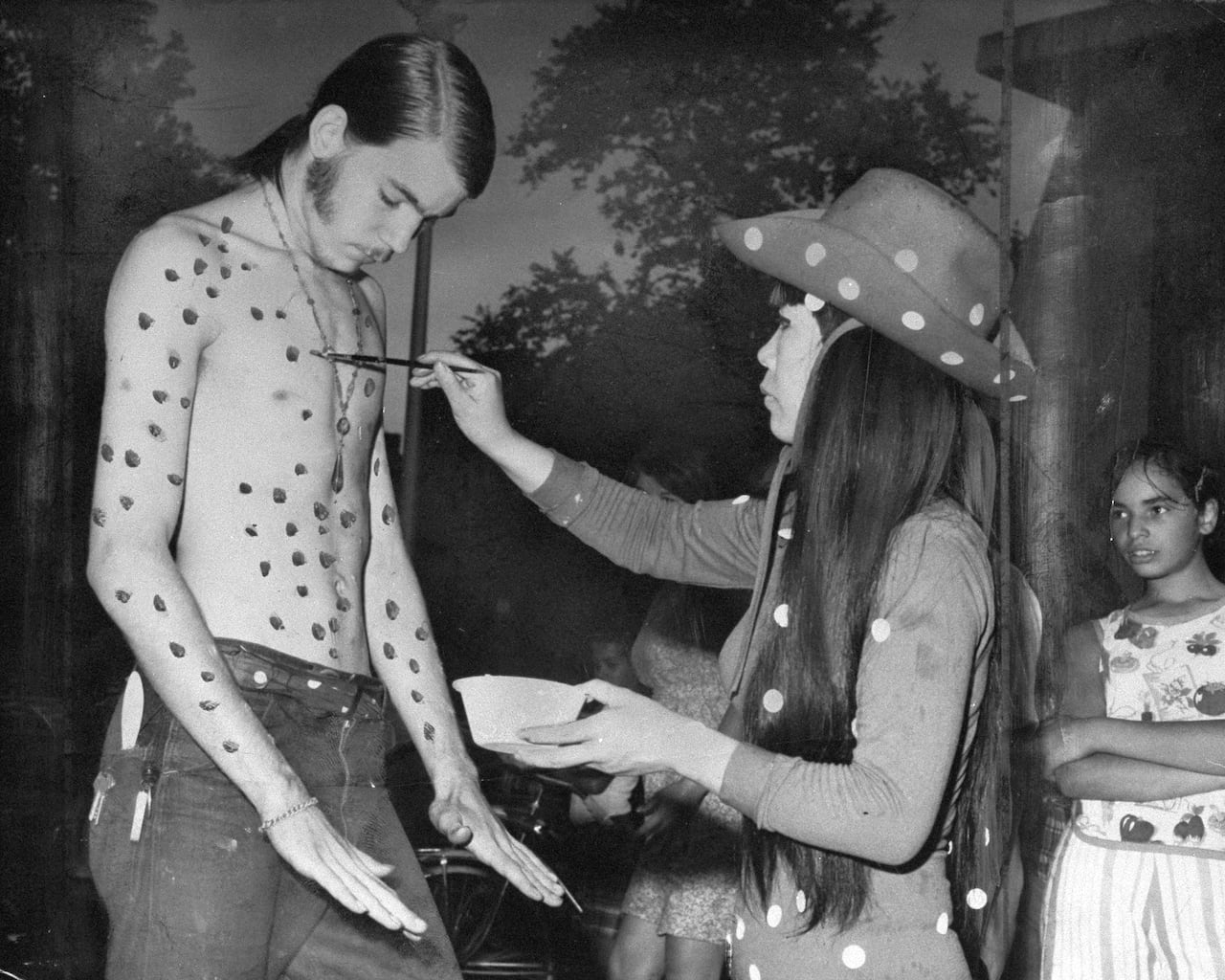 A picture of a man being painted by Yayoi Kusama