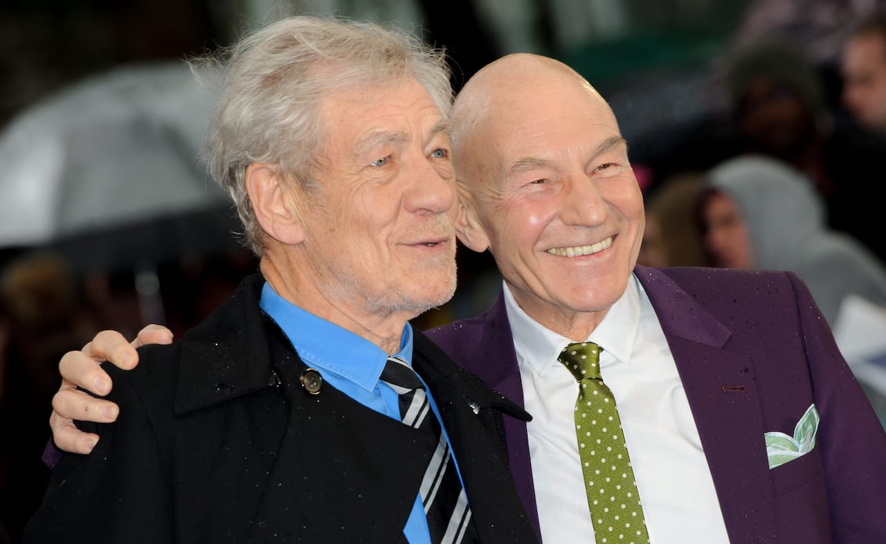 Two men pose together, one smiling, the other in the middle of speaking.