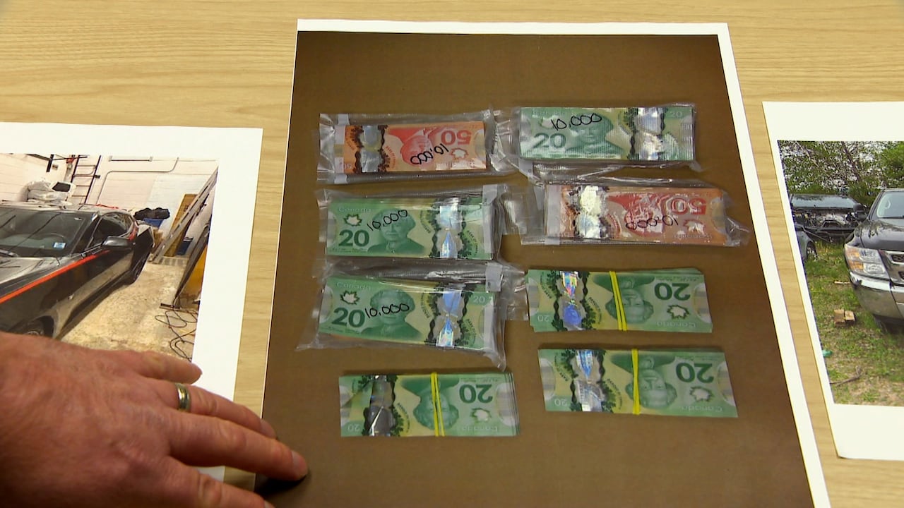 指向现金和车辆照片的新斯科舍骑警警官