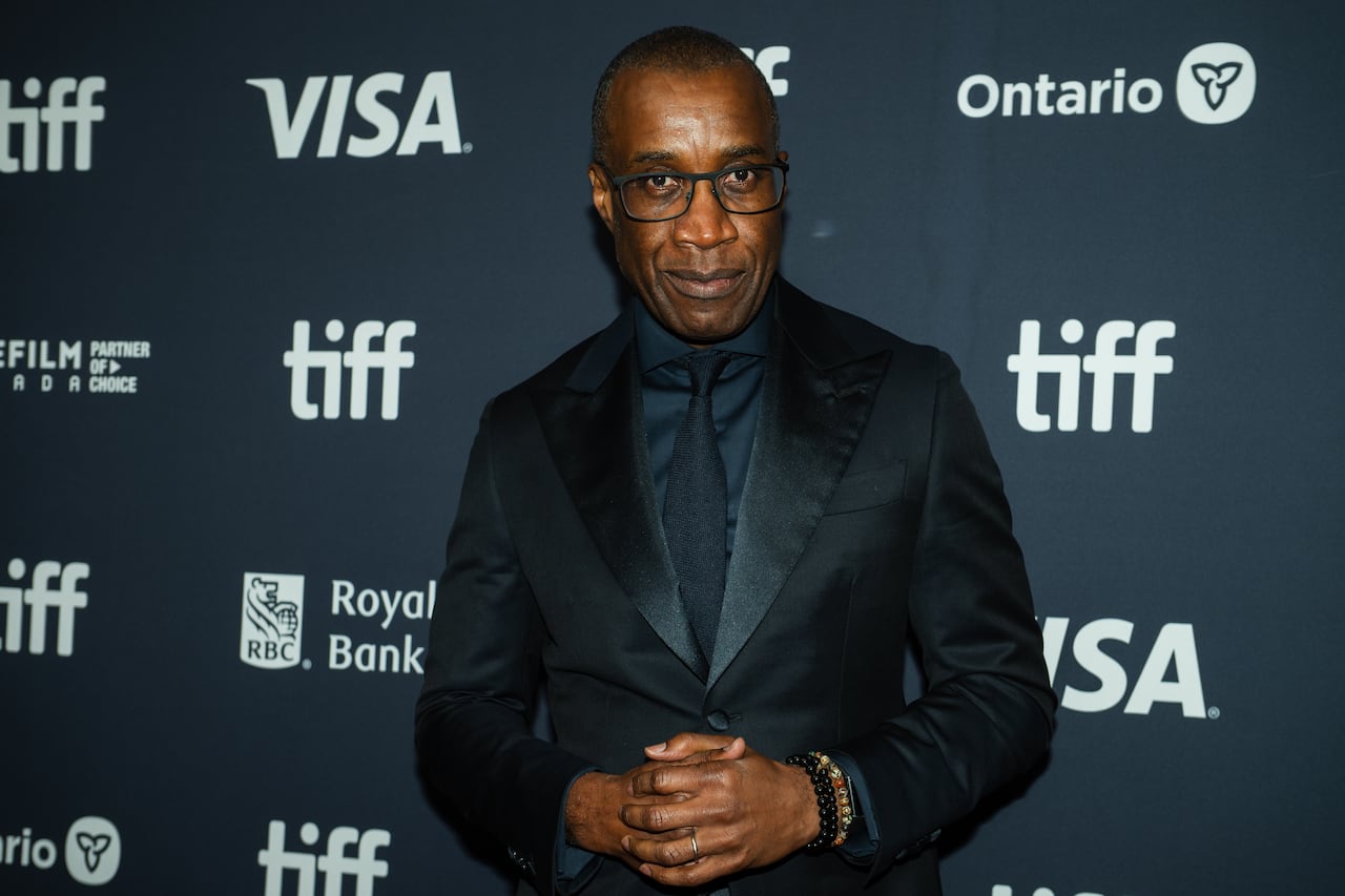 A man in a black suit poses