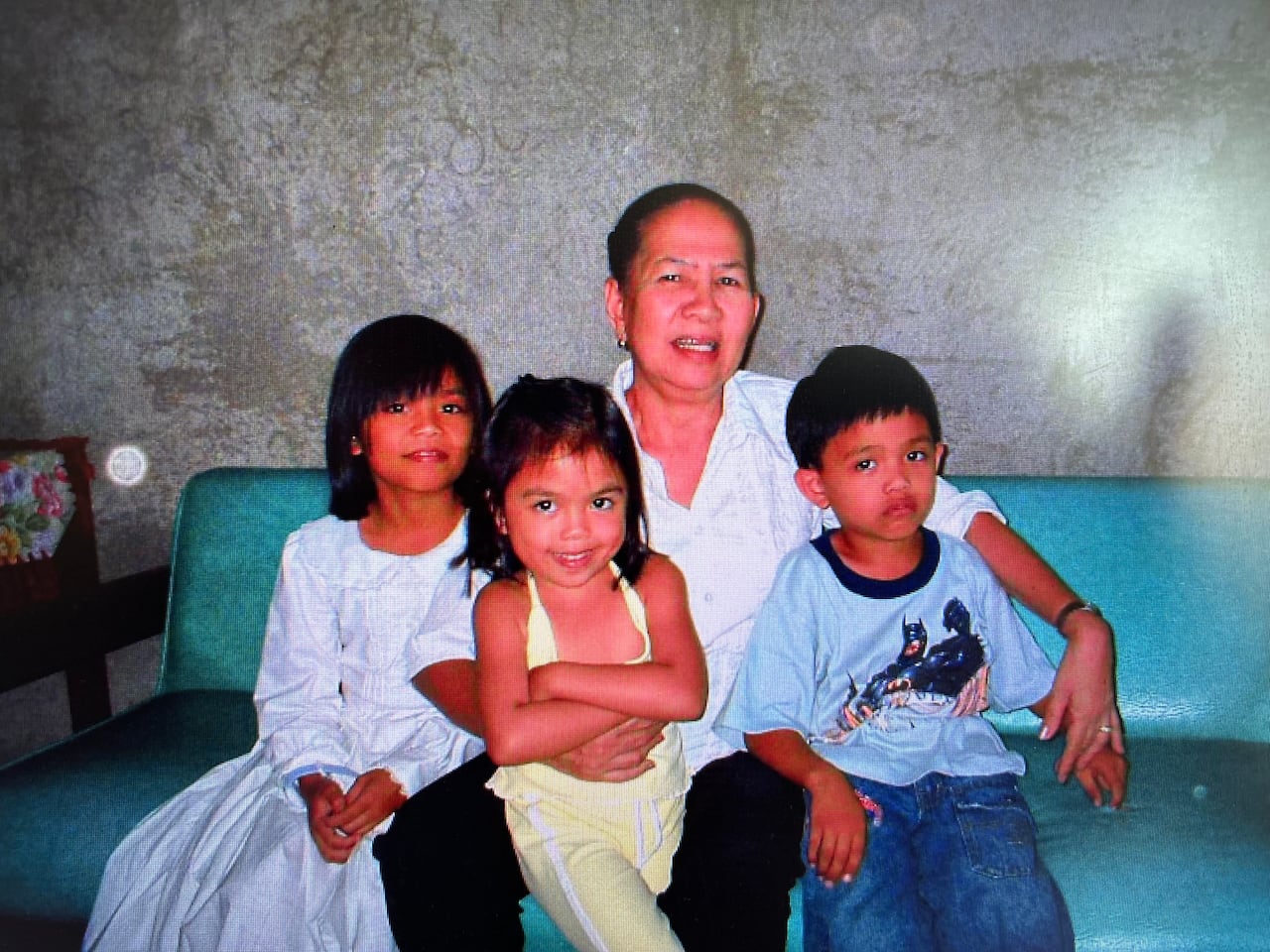 Three children sit with their grandmother.