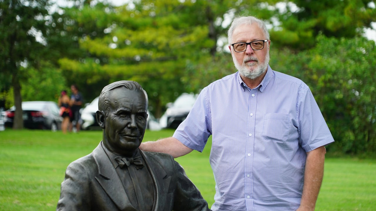 Don Bourgeois, chair of the board and president of Createscape Waterloo Region, stands beside a statue of Lester B. Pearson. Bourgeois said the project is returning with an educational component to provide context behind each prime minister.