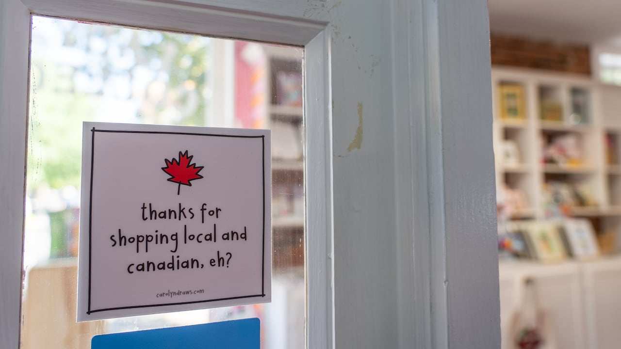sticker written "thanks for shopping local and canadian, eh" at the door of a gift shop
