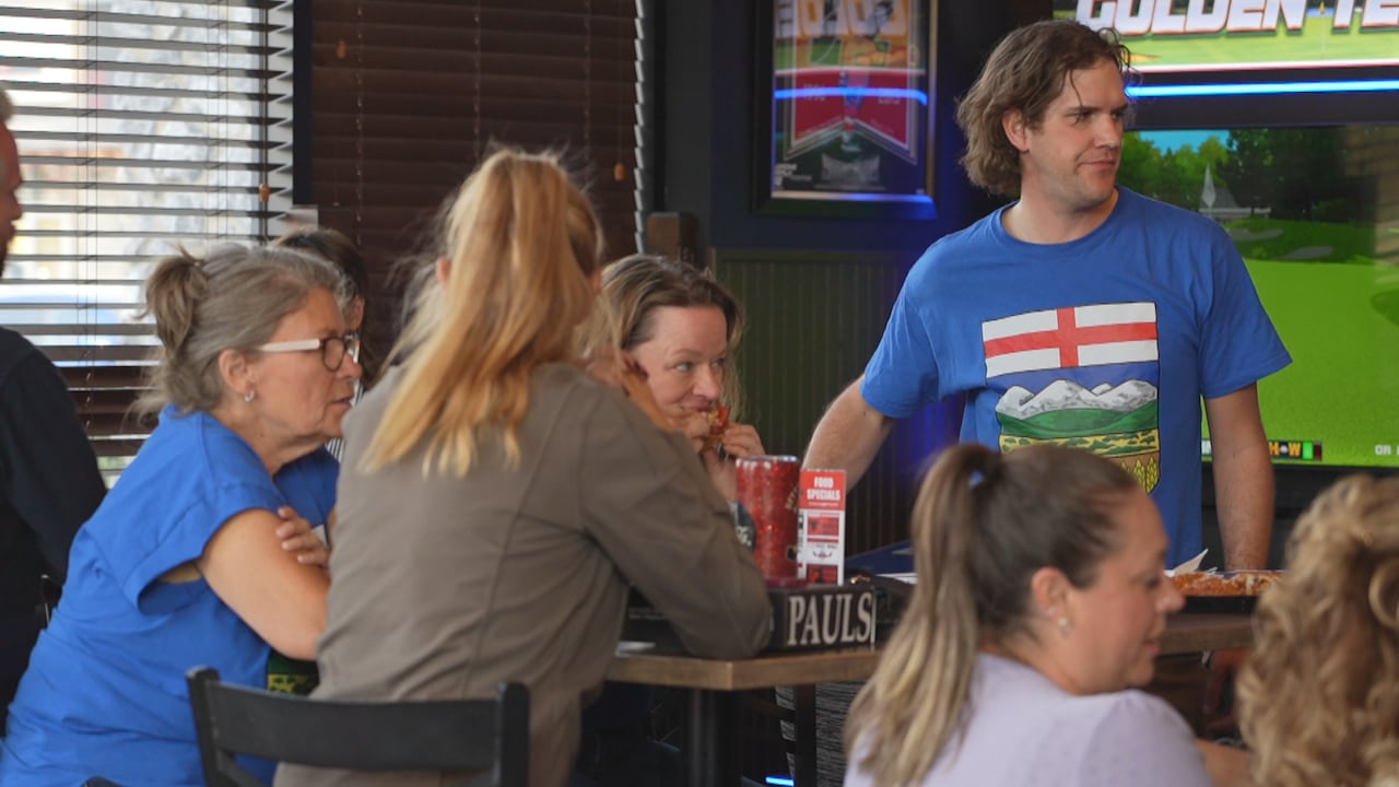 A crowd of people wearing Alberta shirts is pictured.