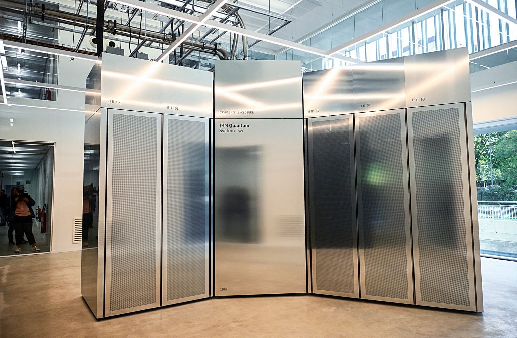 A large, shiny silver container holding a quantum computer sits in an open area.