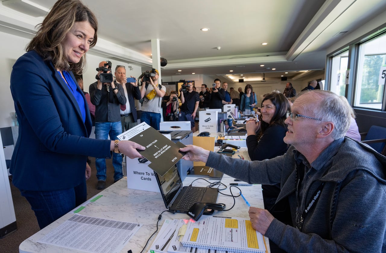 Alberta UCP Leader Danielle Smith receives her ballot to vote at an advance voting station for the upcoming provincial election in Calgary on Tuesday, May 23, 2023.