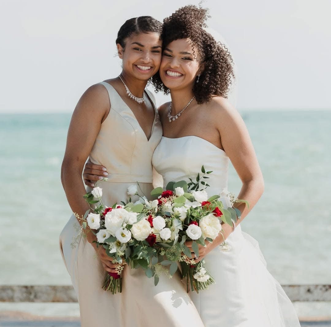 Two women in a bridesmaid and a wedding dress.