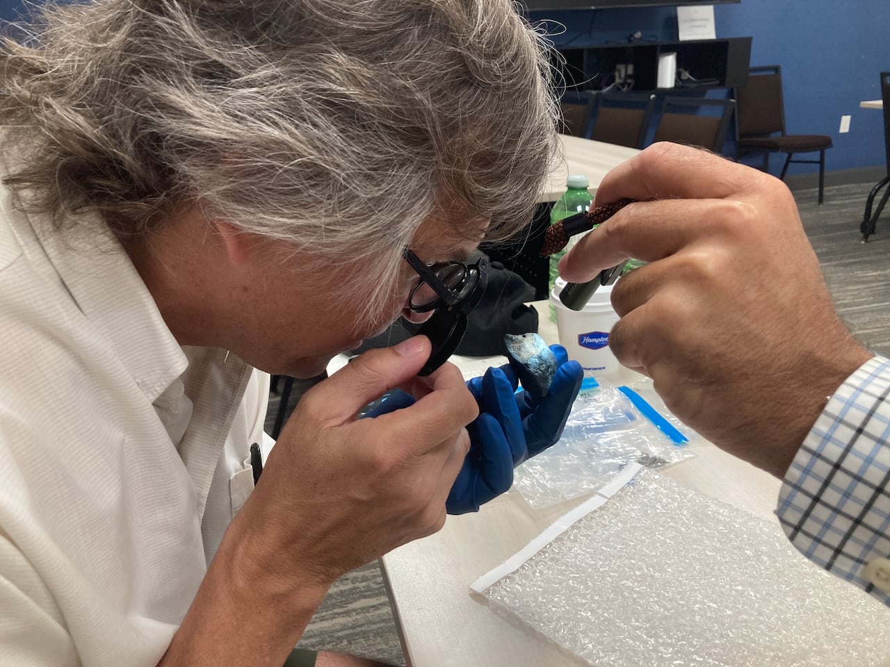 Man analyzes meteorite inside university faculty room.