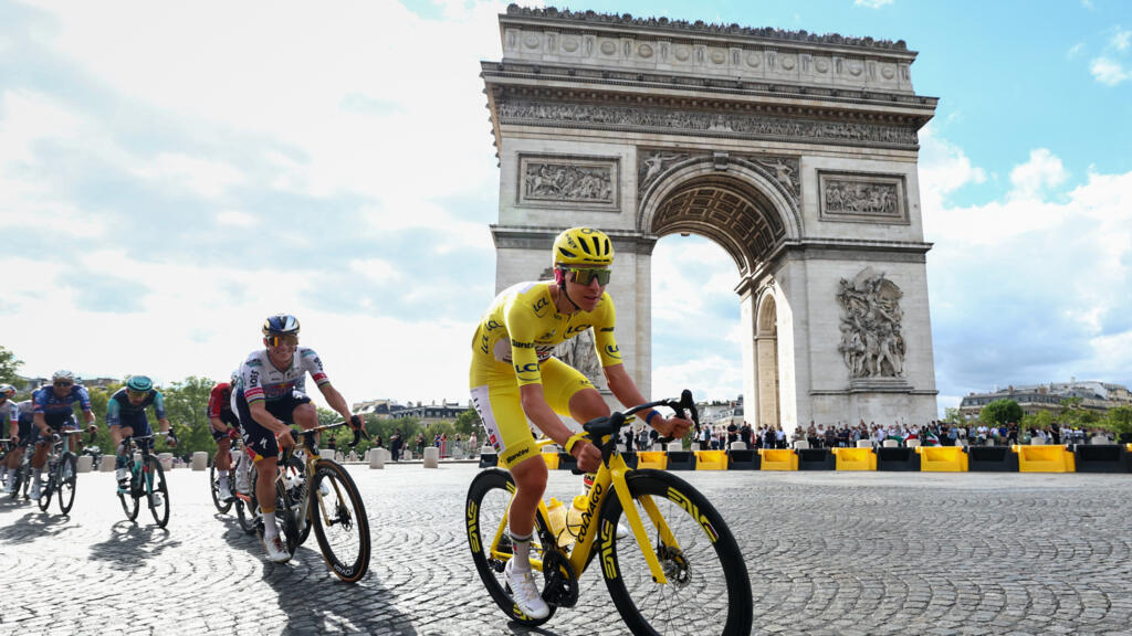 Le coureur slovène Tadej Pogacar, suivi par le coureur belge Remco Evenepoel, passe devant l'Arc de Triomphe lors de la 21e étape de la 113e édition du Tour de France, le 26 juillet 2026.