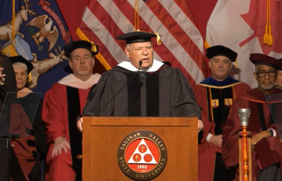 Doug Ford at podium in graduation garb.