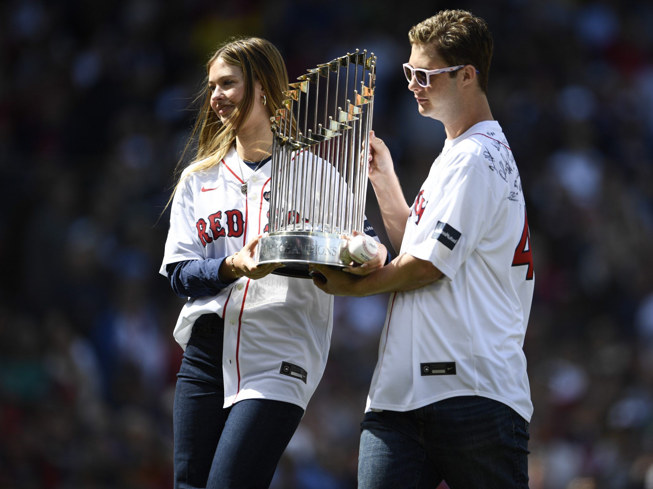 Brianna Grace Wakefield, left, and Trevor Wakefield hold the 2004 World Series trophy.