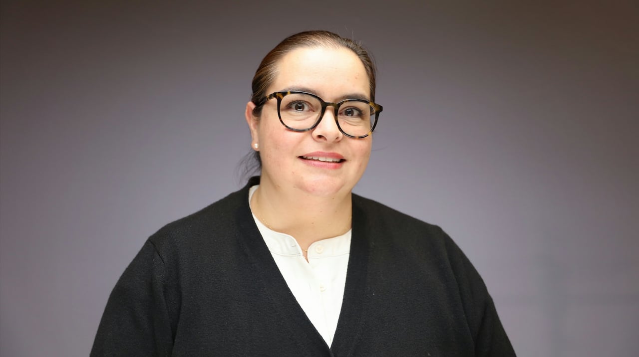Etna Rodriguez wearing glasses and a black cardigan.