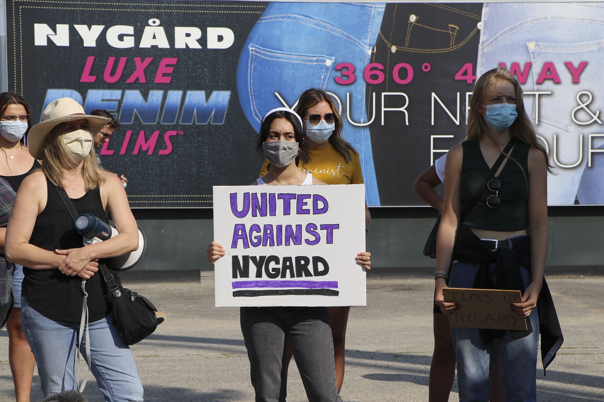 People hold signs at the Time's Up Nygard protest against Canadian fashion mogul Peter Nygard in Winnipeg on Wednesday, Aug. 26, 2020. THE CANADIAN PRESS/Kelly Geraldine Malone