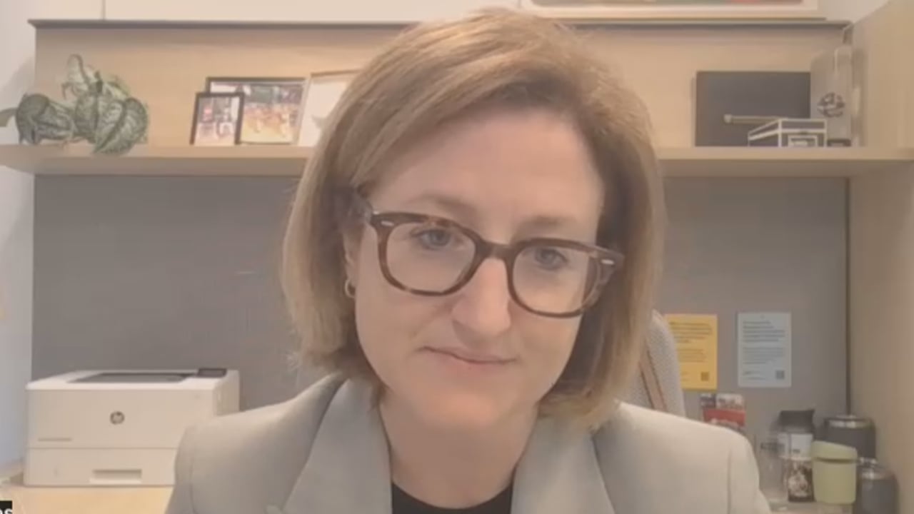 Screenshot of a Zoom call showing a woman in a blazer