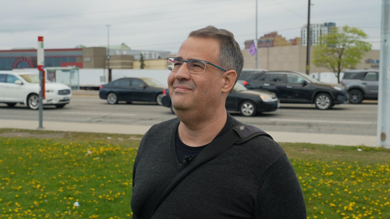 Man looking up in front of a road.