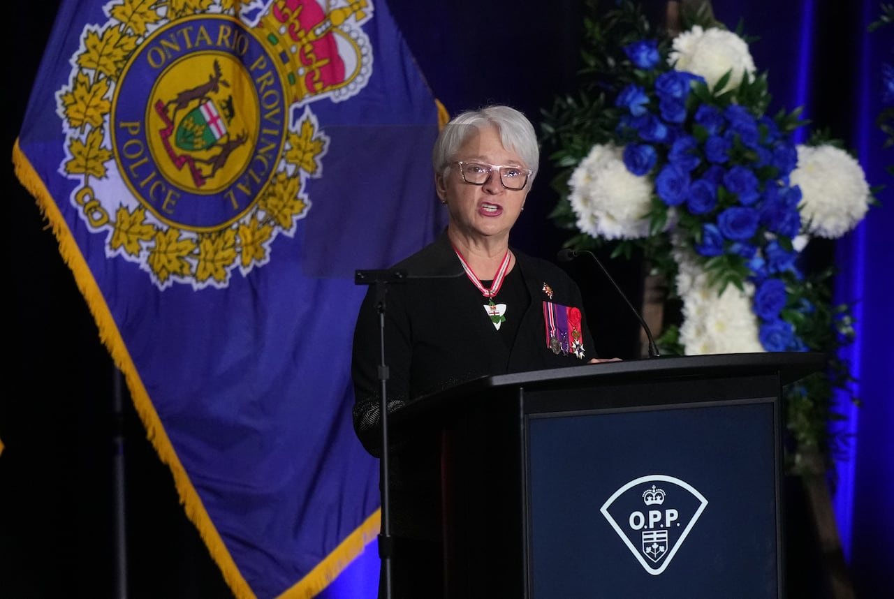 Woman with medals speaks at podium