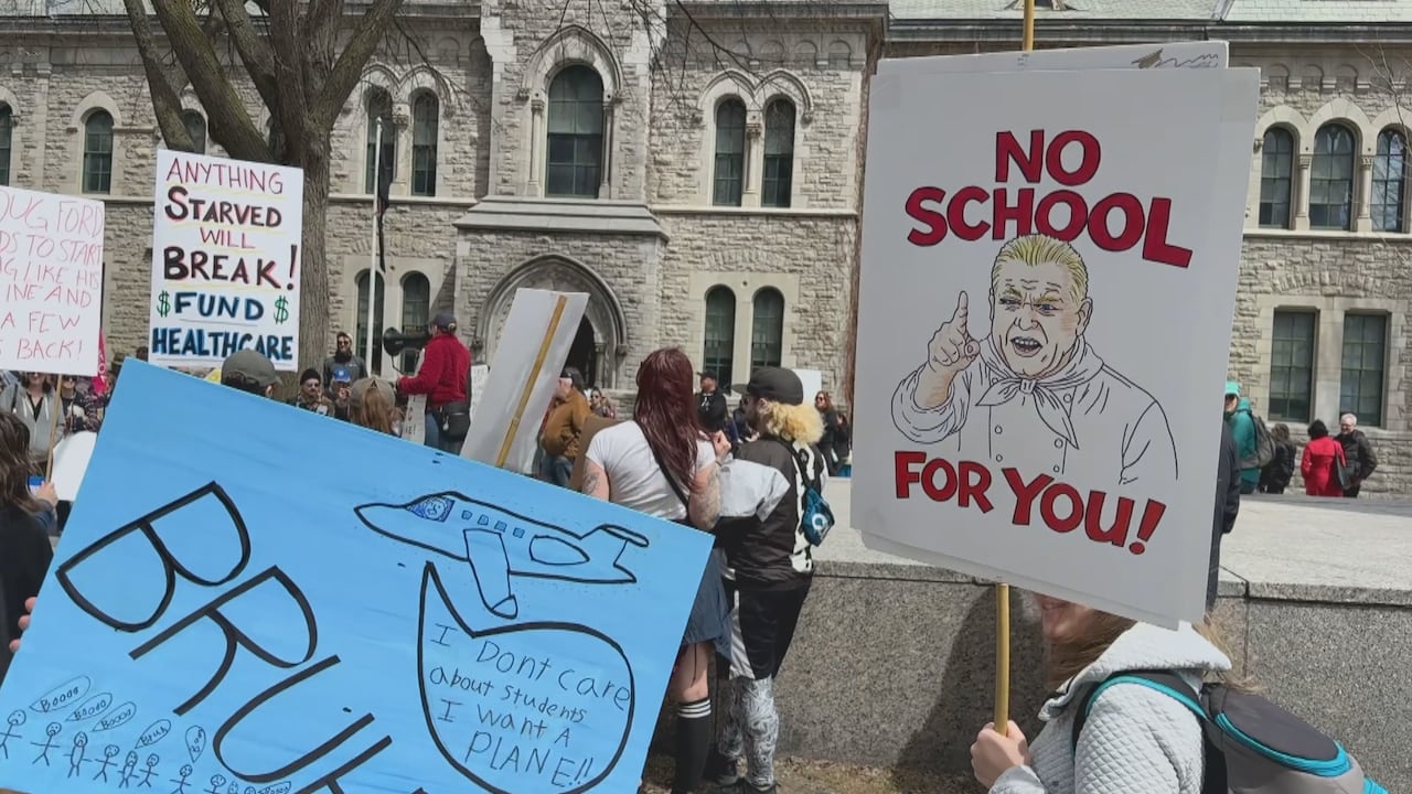 Protesters holding up signs in crowd of people