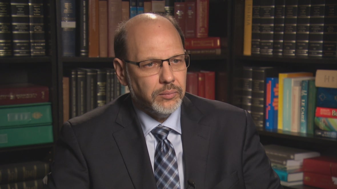 Howard Sapers, corrections reform advisor for the Ontario government, sits in office with book shelves in bg.