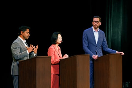 two men and a woman at lecterns on a stage