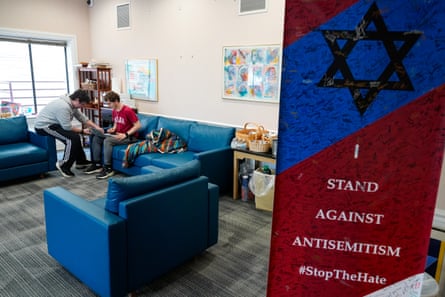 Students sit on blue couches amid gray industrial carpeting in a brightly lit conference-type room.