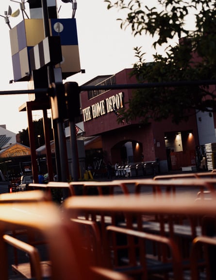 A view of a home depot store front, orange carts in the foreground