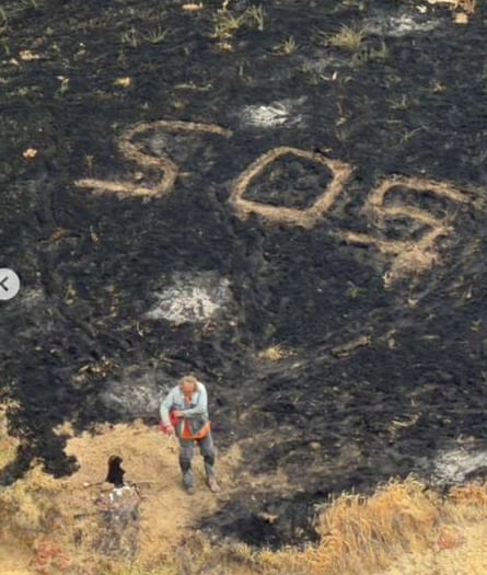 a man in front of a ‘SOS’ sign 
