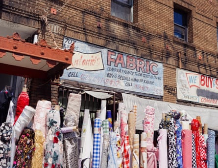 Rolls of fabric in front of a brick fabric storefront