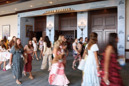 a blurred group of women in floral and frilly dresses