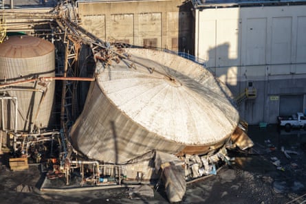 Aerial view of white metal tank collapsed.