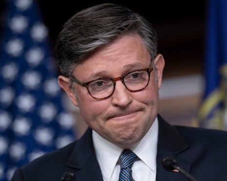 Man in suit grimaces.