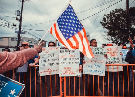 A rightwing counterprotester holds a flag as they face off against anti-ICE protesters in front of Delaney Hall detention facility, in New Jersey, on Saturday.